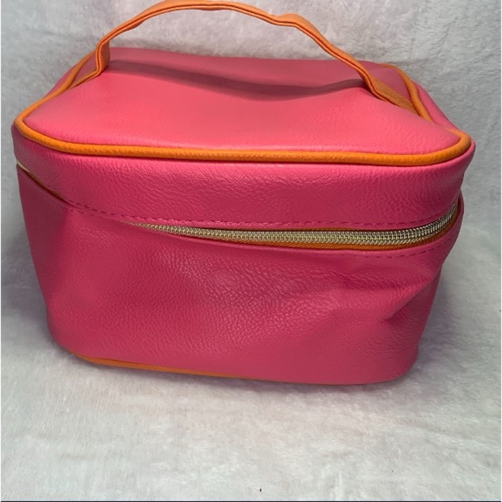 Pink makeup bag with orange lining and zipper closure